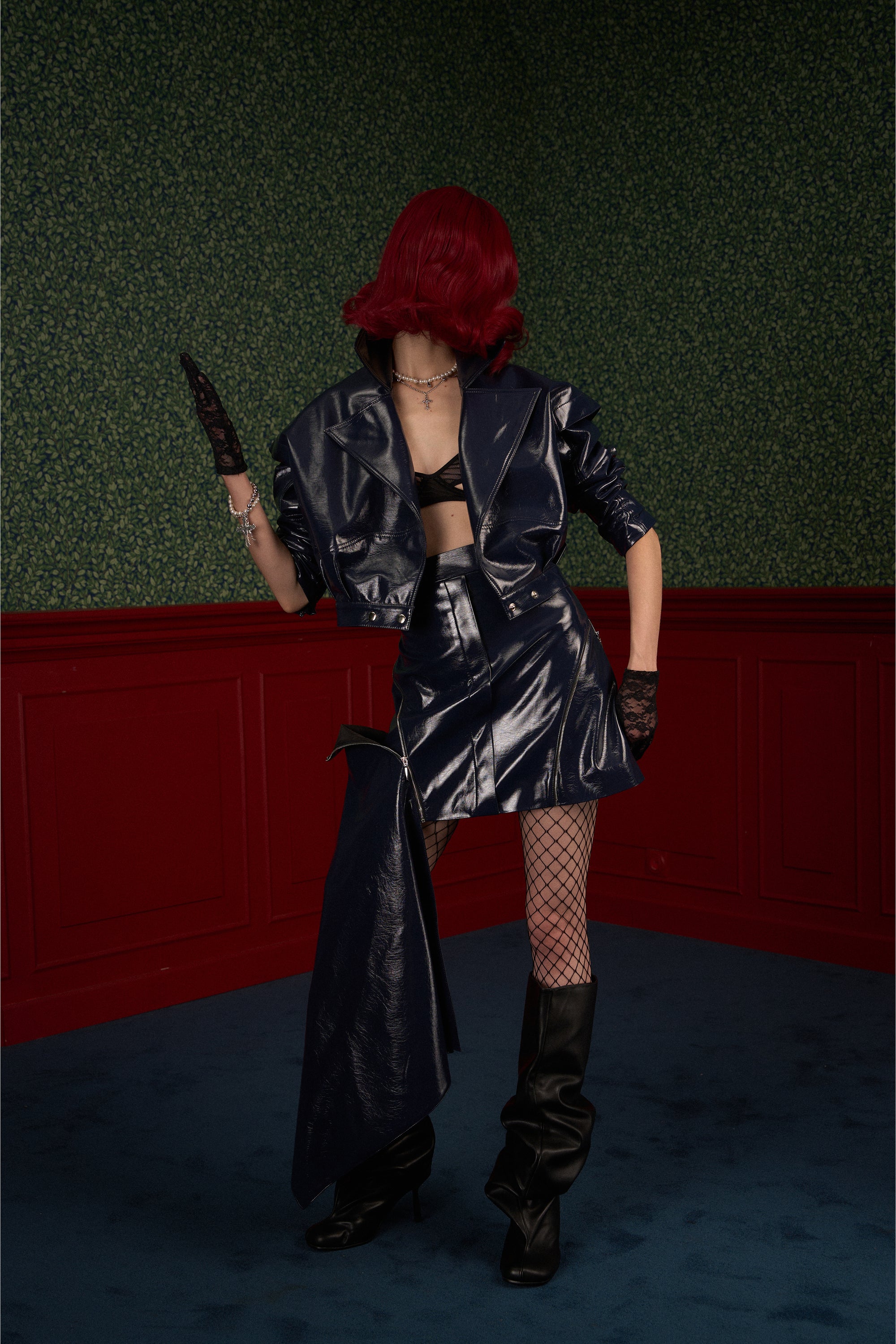 Model in navy asymmetric vegan leather skirt with the side panel partially unzipped for an effortless edge look