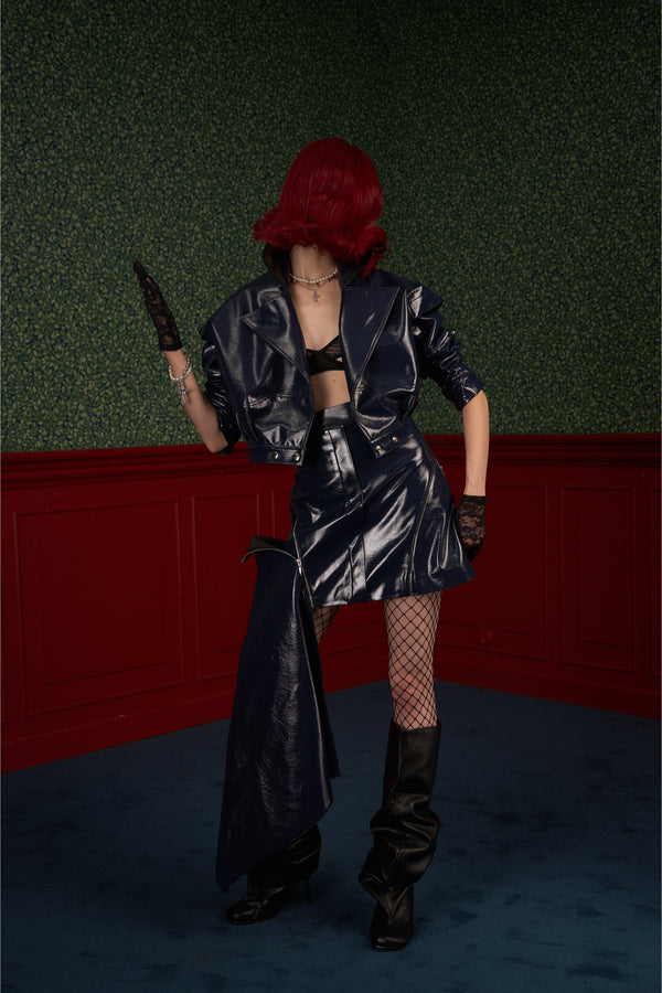 Model in navy asymmetric vegan leather skirt with the side panel partially unzipped for an effortless edge look