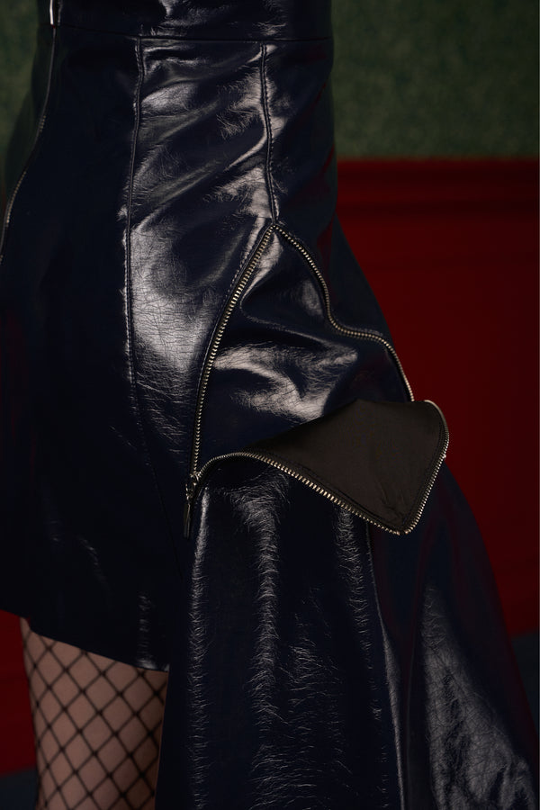 Close-up of the metal zipper that detaches the removable panel on the "The Weapon" navy asymmetric vegan leather skirt